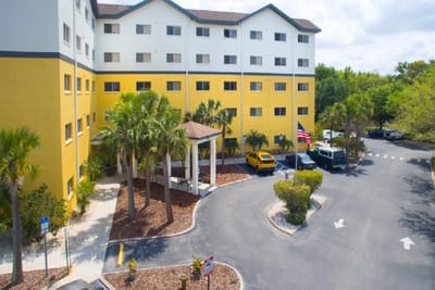Exterior view of Presbyterian Towers with palm trees.