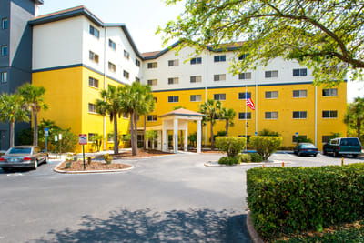 Exterior view of Presbyterian Towers with palm trees.