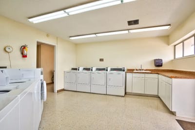 Laundry room with several washers and dryers
