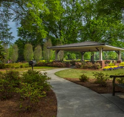 Serene garden path with gazebo and lush greenery.