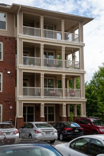 Exterior of the building with balconies and parked cars.
