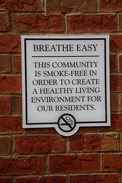 Smoke-free community sign on a brick wall.
