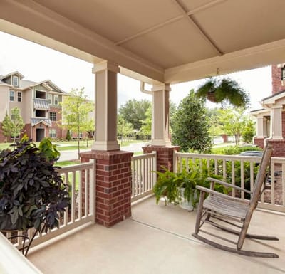 Porch with rocking chair and view of greenery