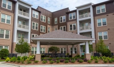 Exterior view of assisted living facility with outdoor seating.