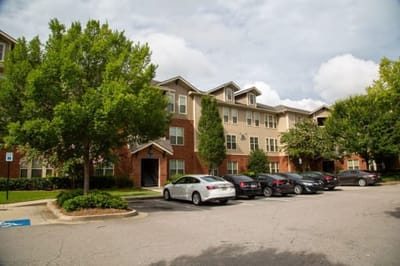 Exterior view of a senior living facility with parking.