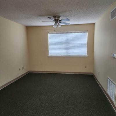 Empty resident room with window and ceiling fan