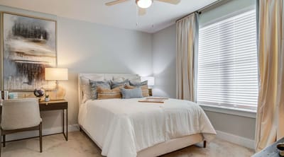 Spacious bedroom with window and elegant decor.