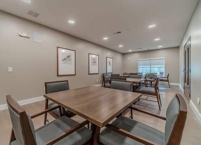 Interior view of a common area with tables and chairs.