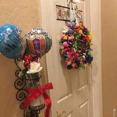 Decorative birthday door with balloons and a wreath