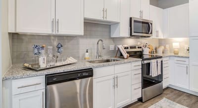 Modern kitchen area with appliances and decor.