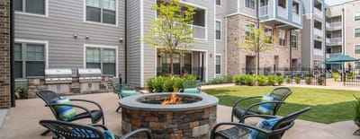 Outdoor fire pit area with seating and greenery.