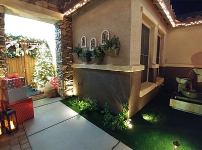 Decorated outdoor space with festive lights and plants.