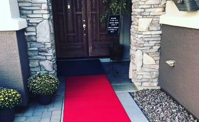 Entrance with red carpet leading to wooden doors.