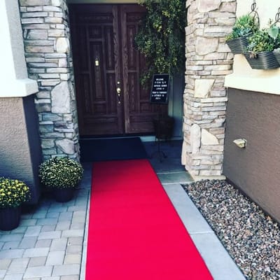Front entrance with a red carpet and stone facade.