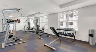 Fitness room with gym equipment and free weights.