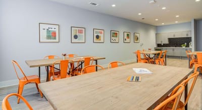 Colorful dining area with wooden tables and art.