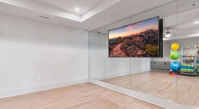 Interior room with a large mirror and exercise equipment.