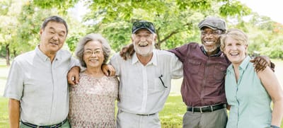 Group of seniors smiling together outdoors.