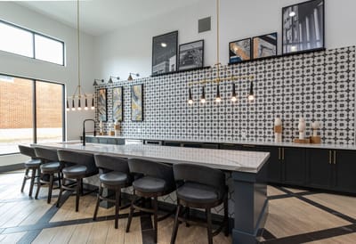 Modern kitchen area with bar seating and decor.