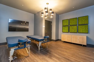 Therapy room with massage tables and modern decor.