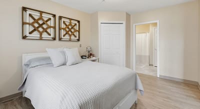 Bright interior of a resident room with bed and decor.