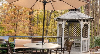 Outdoor gazebo with seating and autumn foliage