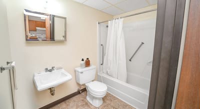 Clean bathroom with sink and shower area.