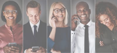 A group of diverse individuals smiling while on phones