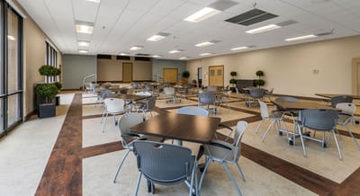 A spacious common area with tables and chairs.