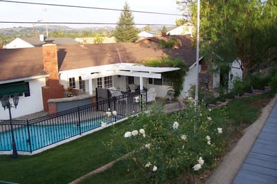 Outdoor view of a residential facility with a pool and garden