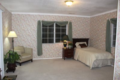 Cozy resident room with floral wallpaper and a bed