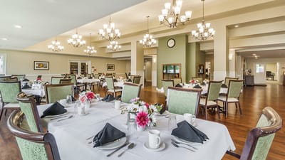 Bright dining room set for a meal with floral centerpieces