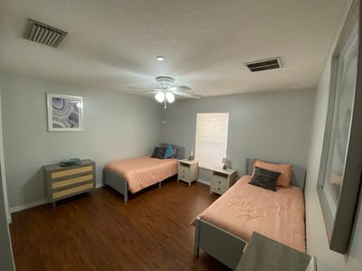 Brightly lit interior room with twin beds and decor
