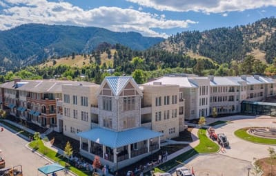 Aerial view of the Academy Boulder Communities building with mountains in the background