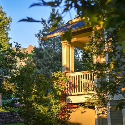 A peaceful outdoor area with trees and a porch