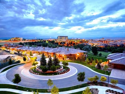 Aerial view of the facility surrounded by gardens at dusk