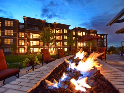 Outdoor seating area with fire feature and building in background