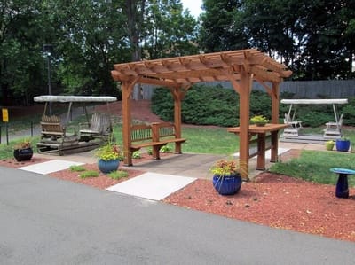 Outdoor seating area with covered pergola and swing chairs