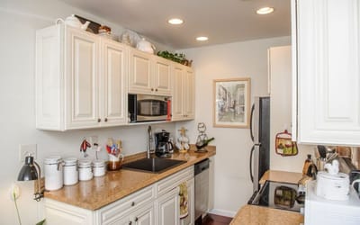 Bright kitchen with white cabinetry and appliances