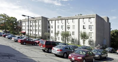 Exterior view of East Gate Apartments building with parking