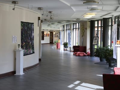 Bright common area hallway with artwork and seating