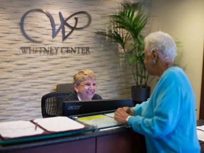 Reception area with staff assisting a resident