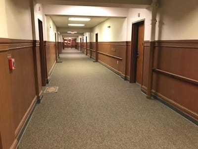 Interior hallway with wooden paneling and carpeting