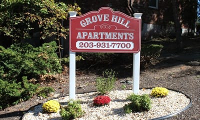 Sign for Grove Hill Apartments surrounded by flowers