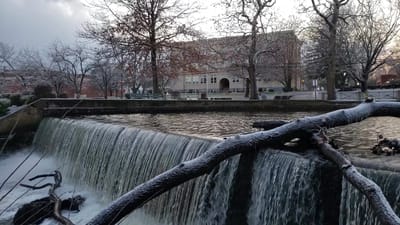 Scenic view of a waterfall with a facility in the background