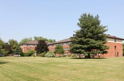 Exterior view of the assisted living facility surrounded by green lawn