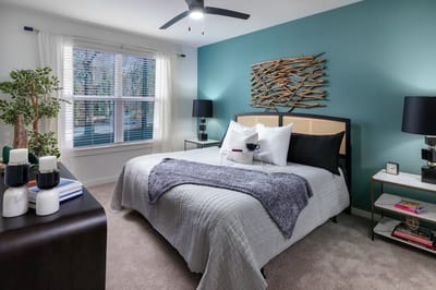 A neatly arranged bedroom with modern decor and natural light