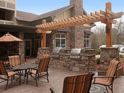 Outdoor seating area with grills and stone structure