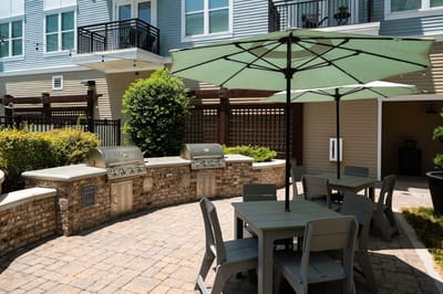 Outdoor grilling area with tables and umbrellas