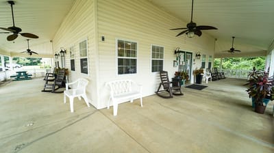 Covered outdoor seating area with chairs and plants